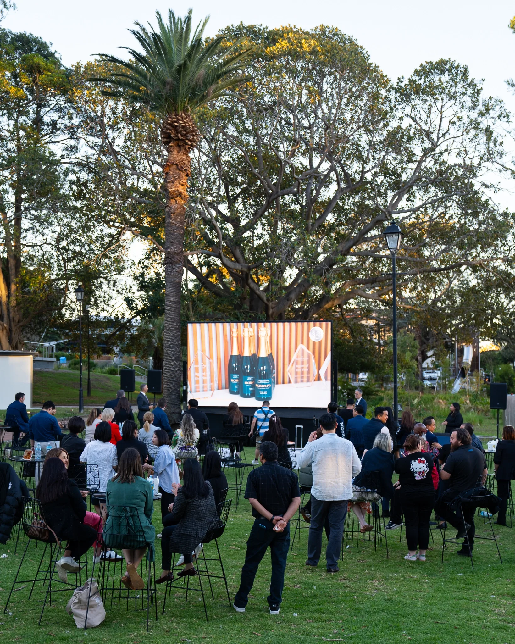 Outdoor awards crowd watching the big screen at Burwood Mayor's Commendation Awards 2025