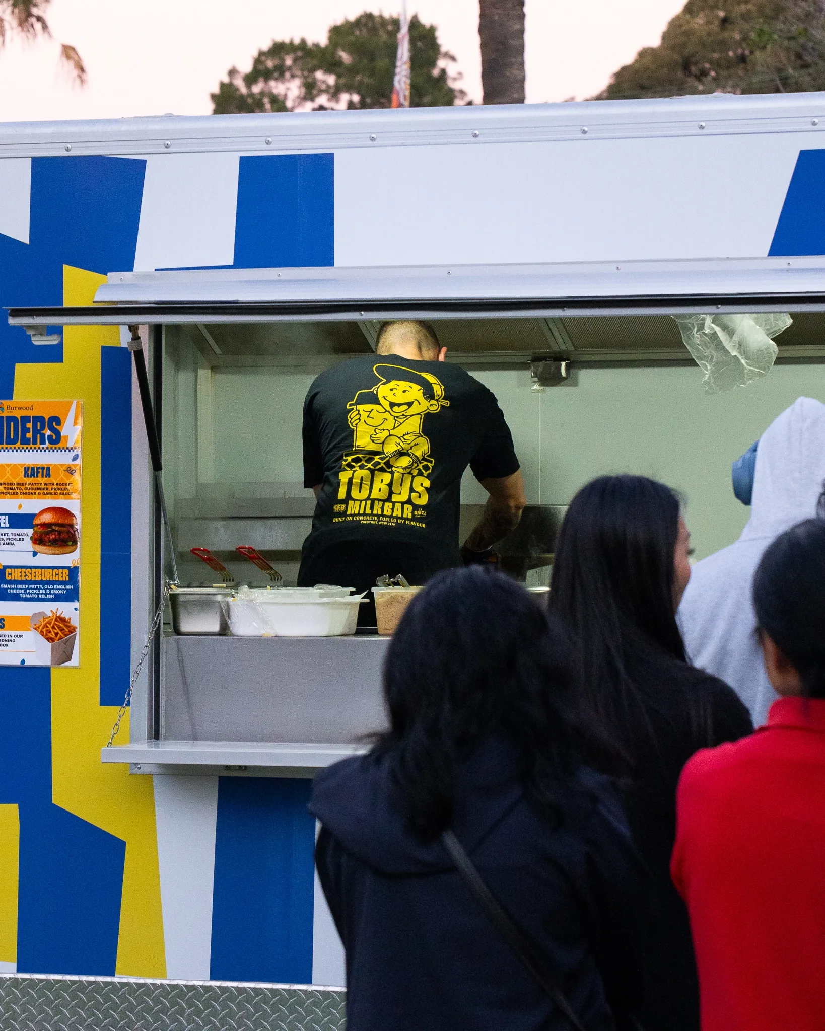 Staff serving from the Toby's Milkbar trailer service window at Burwood Council awards night